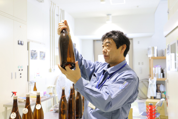 Tomoaki Saito, chief manager of Fermented Food Development Department at Hirosaki Industrial Research Institute, is checking haziness of sake on experiment.