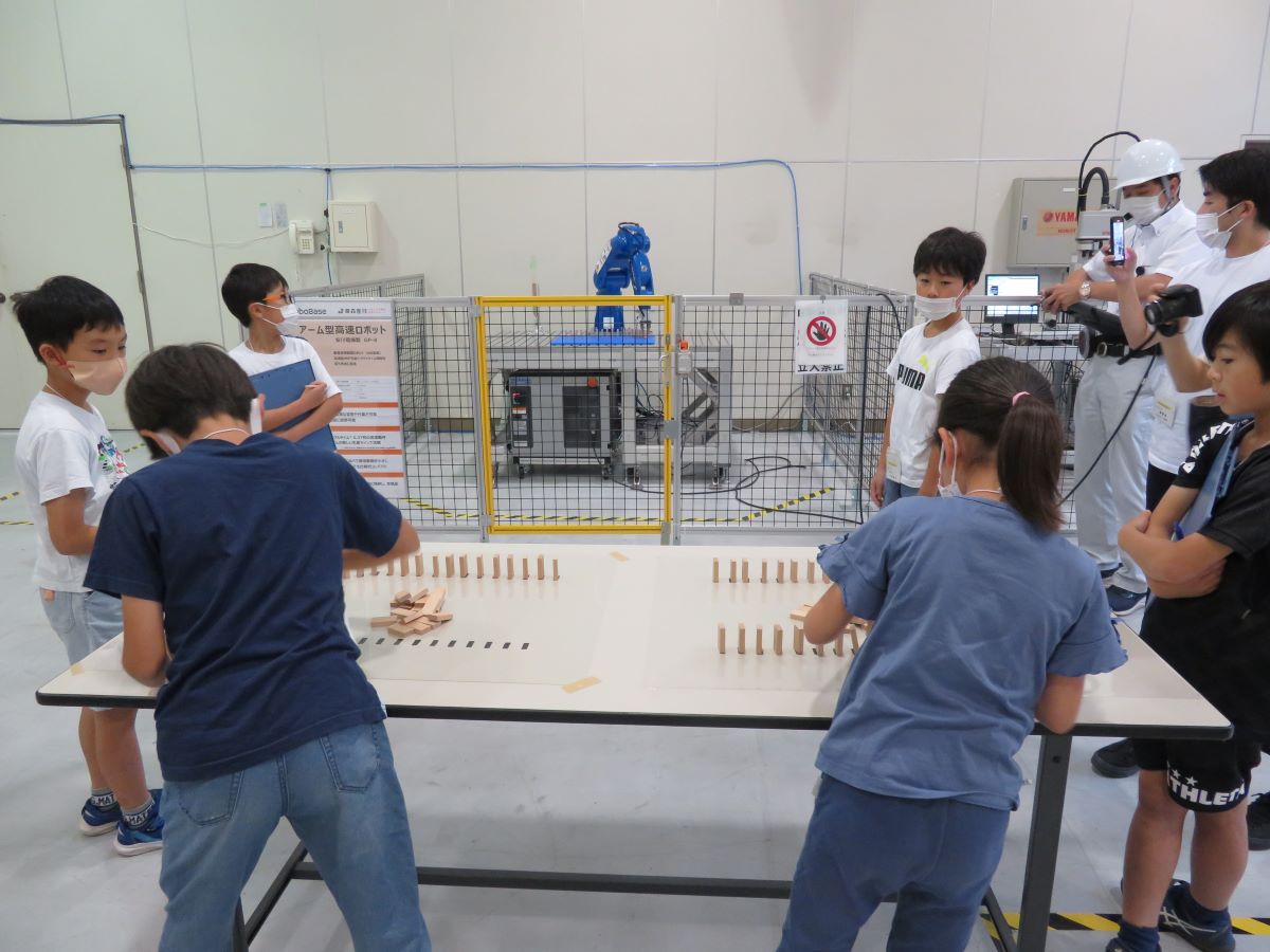 写真：アーム型高速ロボットとのドミノ並べ競争